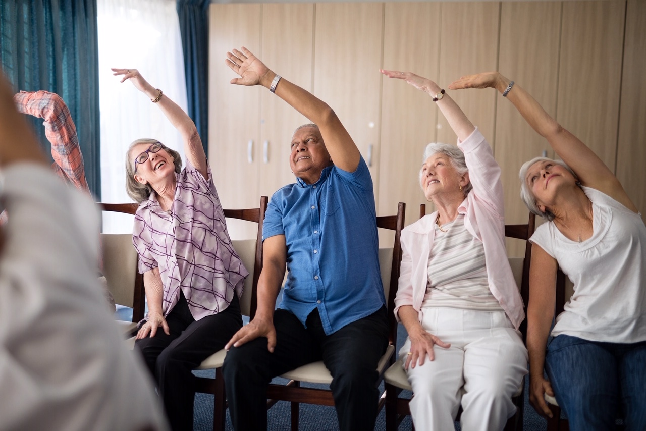 Smiling senior people stretching with female doctor